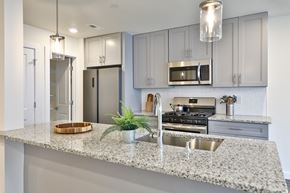 Philadelphia apartment for rent - a kitchen with grey cabinets and a granite counter top