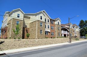 Hazleton apartment for rent - A large apartment building with a stone facade and multiple balconies.