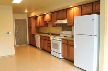 Hazleton apartment for rent - A kitchen with white appliances and wooden cabinets.