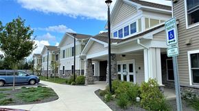 Lake Ariel apartment for rent - A blue van is parked in a driveway in front of a building with a sign that says "Reserved Parking.".