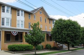 Stoystown apartment for rent - A building with a red, white and blue sign on the front.