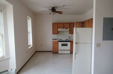 Stoystown apartment for rent - A kitchen with white appliances and wooden cabinets.