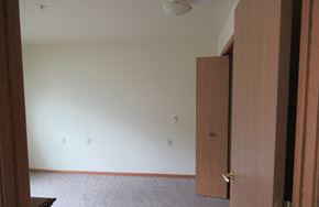 Mount Pocono apartment for rent - A room with a brown door and a carpeted floor.