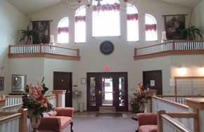 Mount Pocono apartment for rent - A church interior with a red bench and a flower arrangement on a table.