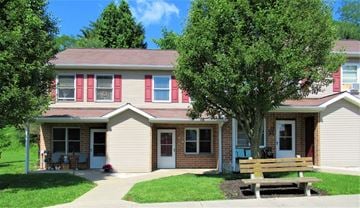 Mcveytown apartment for rent - A house with a red door and a bench in front.