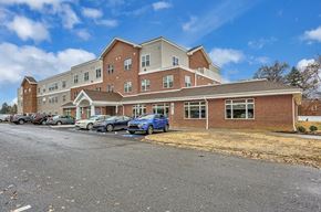 Harrisburg apartment for rent - A large multi-story building with a parking lot in front.