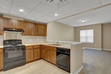 Harrisburg apartment for rent - A kitchen with wooden cabinets and a black stove top oven.
