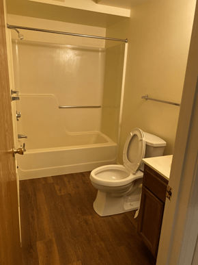 Pine Grove apartment for rent - A white toilet in a small bathroom with wood flooring.