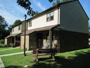 Pine Grove apartment for rent - A house with a brown roof and a bench in front of it.