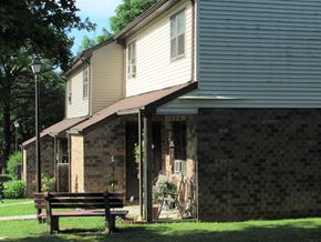Pine Grove apartment for rent - A house with a brown bench in front of it.