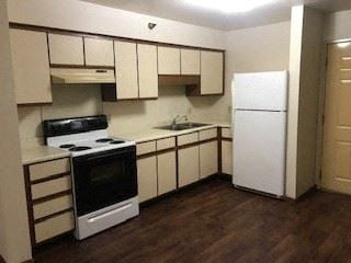 Mcveytown apartment for rent - A kitchen with a white fridge and black stove.