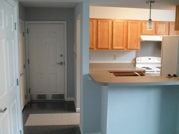 Coatesville apartment for rent - A kitchen with wooden cabinets and a white fridge.