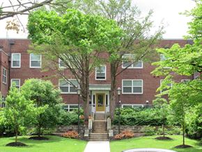 Coatesville apartment for rent - A red brick building with a wooden door and steps leading up to it.
