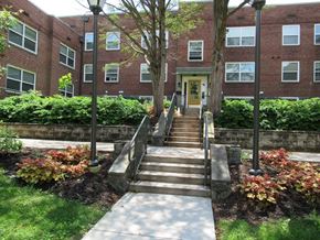 Coatesville apartment for rent - A red brick building with a yellow door and steps leading up to it.