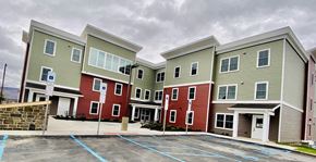 Pittston apartment for rent - A parking lot in front of a building with a red and green facade.