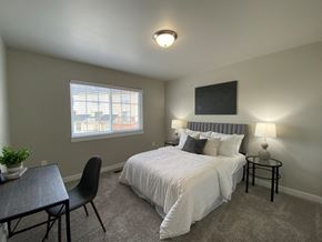 Shelby Township apartment for rent - a bedroom with a bed and a desk and a window