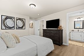Shelby Township townhouse for rent - A bedroom with a large bed and a TV.