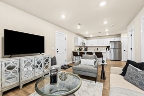Sterling Heights apartment for rent - A modern living room with a glass coffee table and a television on the wall.