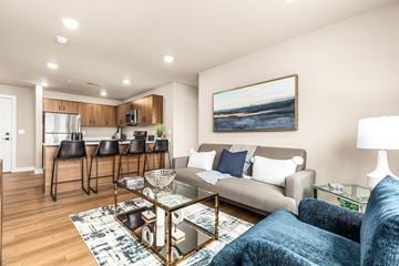 Sterling Heights apartment for rent - A living room with a grey couch and a painting on the wall.