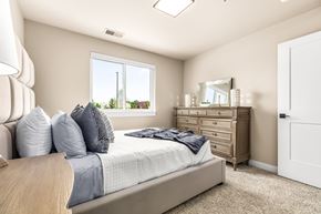 Sterling Heights apartment for rent - A bedroom with a bed, dresser, mirror, and window.
