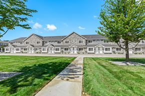 Shelby Township townhouse for rent - A large building with a tree in front of it.