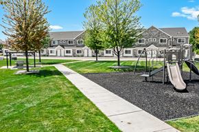 Shelby Township townhouse for rent - A playground with a slide and a walking path in front of a building.