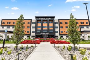 Sterling Heights apartment for rent - a large building with a sidewalk and trees in front of it