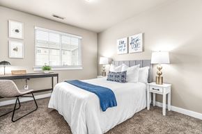 Sterling Heights apartment for rent - A bedroom with a white bed and a blue throw blanket.