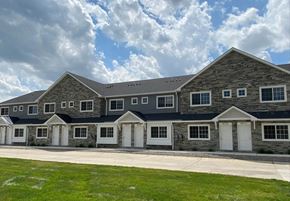 Shelby Township apartment for rent - a large brick house with white doors and a blue roof