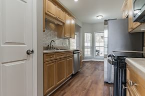 Helena house for rent - a kitchen with wooden cabinets and stainless steel appliances and a window