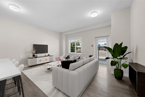 Calgary apartment for rent - a living room with a white couch and a table and a television