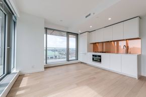 Vancouver condo for rent - A kitchen with white cabinets and a wooden floor.