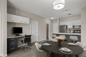 Airdrie apartment for rent - a dining room and kitchen with a table and chairs and a tv