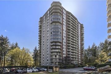 North Vancouver condo for rent - A tall residential building with a parking lot in front.