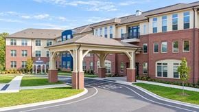 Charlotte apartment for rent - A large building with a covered walkway in front.