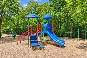Charlotte apartment for rent - A playground with a blue slide and red and blue swings.