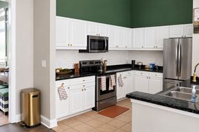 Charlotte apartment for rent - A kitchen with white cabinets and black countertops.