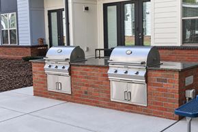Charlotte apartment for rent - Two silver barbecues are built into a brick wall.