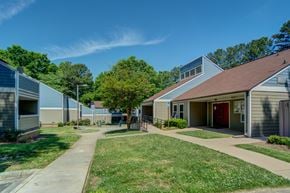 Charlotte apartment for rent - A sunny day at a residential complex with green lawns and trees.