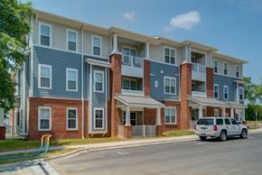 Charlotte apartment for rent - A row of townhouses with a car parked in front.