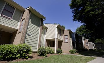 Charlotte apartment for rent - Apartment building with green bushes in front.