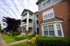 Charlotte apartment for rent - A two-story brick building with a balcony and a small porch.