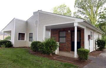 Charlotte apartment for rent - A small house with a white siding and a brick chimney.