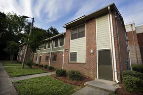 Charlotte apartment for rent - A brick house with a green door and a grey garage door.
