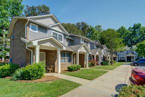 Charlotte apartment for rent - A row of houses with a red car parked in front of the first house.