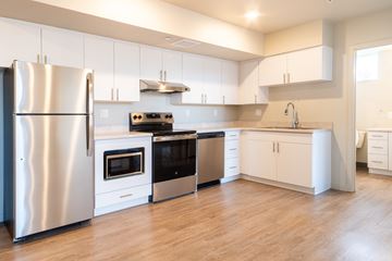 Denver apartment for rent - A modern kitchen with a stainless steel refrigerator and white cabinets.