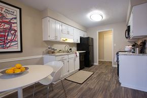 Atlanta apartment for rent - a kitchen and dining room with white cabinets and a black refrigerator