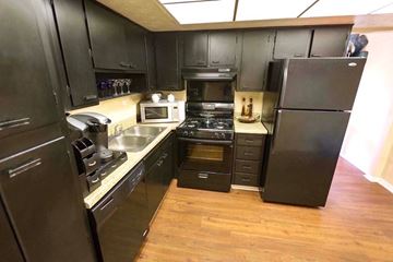 Atlanta apartment for rent - A kitchen with black cabinets and a black refrigerator.