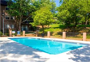Atlanta apartment for rent - A swimming pool surrounded by a fence and trees.