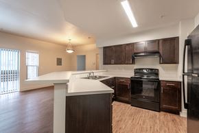 Aurora apartment for rent - Kitchen with dark brown cabinets, black appliances, grey countertops